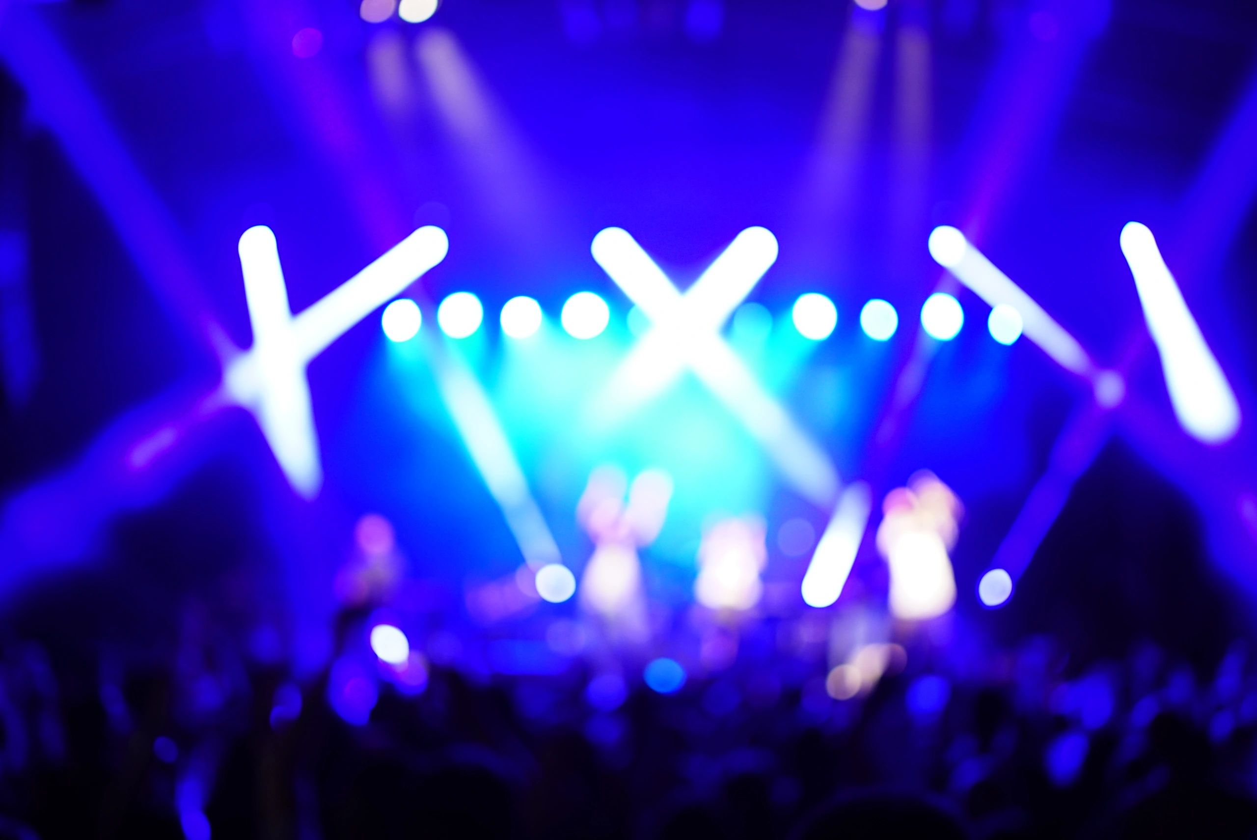 Escenario con público y pantalla LED iluminando el show