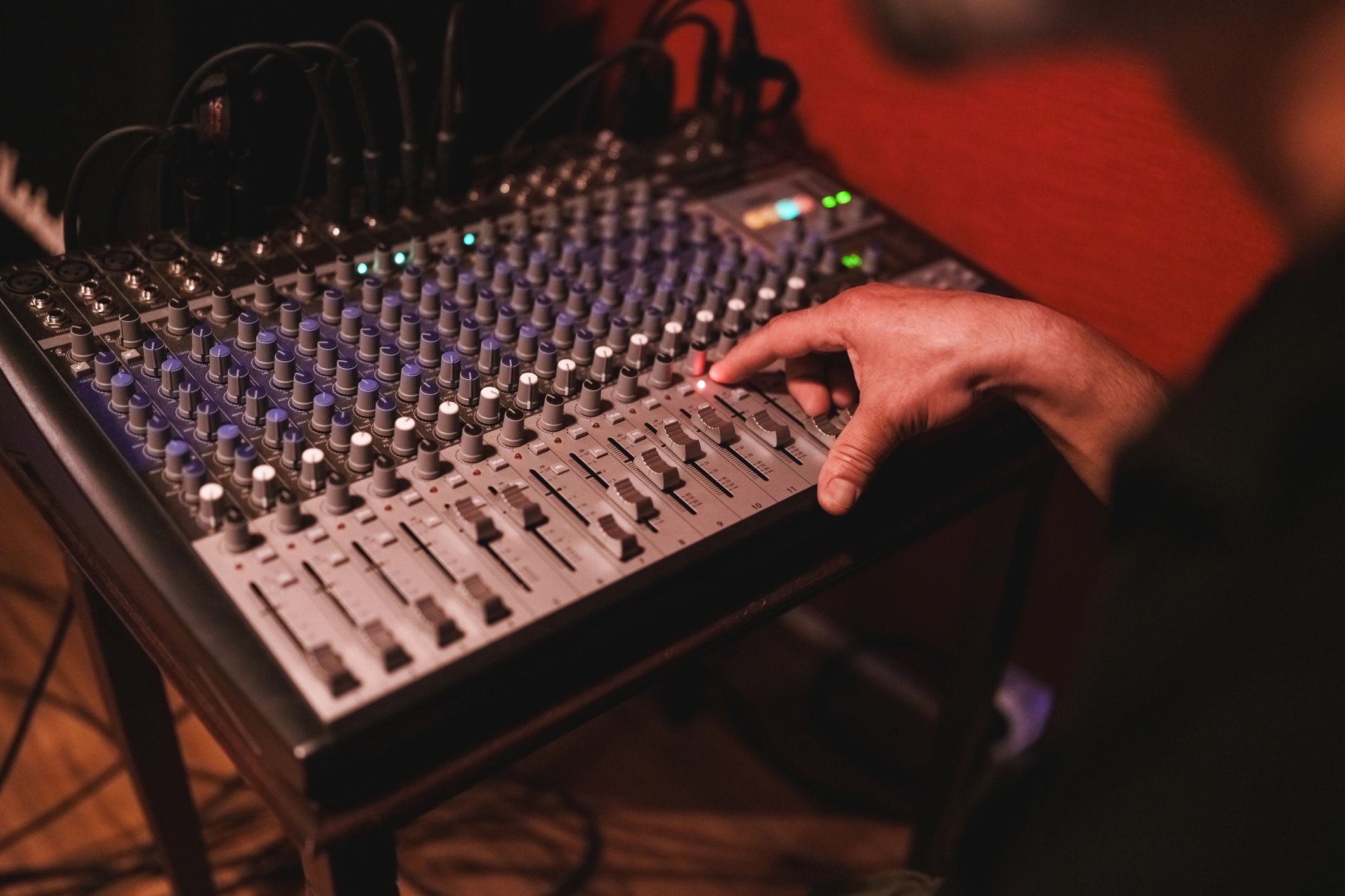 Manos operando una consola de audio